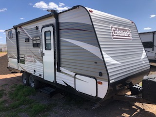 Travel trailer parked in an open space with other RVs nearby